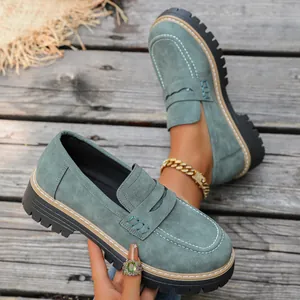 Detailed view of vintage teal suede loafers with chunky platform lug soles and white stitching