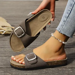 Détail de sandales à boucles marron avec semelles en liège et assise plantaire confortable.