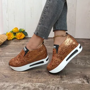 Vista dettagliata di sneaker con zeppa da donna con stampa pitonata marrone e suola spessa