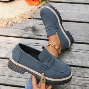 Close-up of blue suede platform loafers with thick soles and British style details