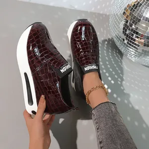 Dettaglio ravvicinato di scarpe platform bordeaux con trama coccodrillo e suola alta