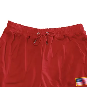 Detailweergave van rode heren joggingbroek met trekkoord en de Amerikaanse vlag patch