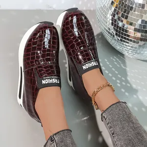 Vista dettagliata delle sneakers platform bordeaux motivo coccodrillo per donna.