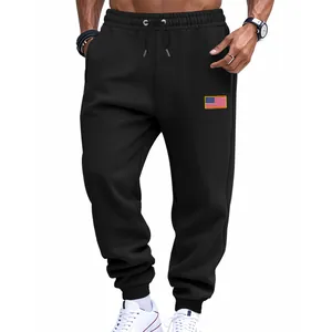Detail van een zwarte heren joggingbroek met trekkoord en een Amerikaanse vlag patch.