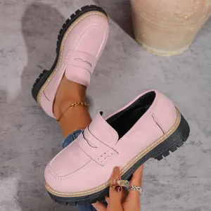 Detailed view of pink chunky platform loafers featuring classic British style and thick black soles