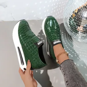 Dettaglio delle sneakers platform verde scuro da donna con motivo coccodrillo e suola ad aria
