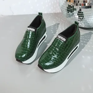 Sneakers con zeppa verde smeraldo, stampa coccodrillo e comodo design senza lacci.