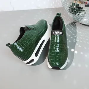 Vista dettagliata di sneakers slip-on verde scuro con stampa coccodrillo e suola