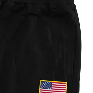 Detailweergave van zwarte heren joggingbroek met geborduurde Amerikaanse vlag patch
