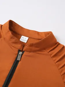 Close-up detail of stand-up collar and silver zipper on orange sports sweatshirt