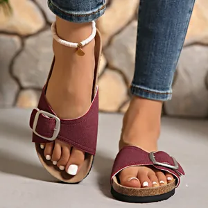 Détail de sandales vintage bordeaux avec grande boucle argentée et semelle en liège