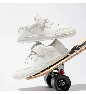 Λεπτομερής πλάγια όψη λευκών αναπνεύσιμων sneakers για παιδιά πάνω σε skateboard