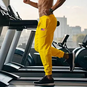 Detail van de pasvorm en trekkoordtaille van de gele Amerikaanse stijl joggingbroek.