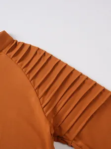 Detailed macro view showing pleated texture on the sleeve of orange men sports top