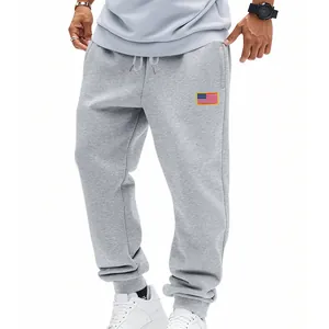 Detail van grijze heren joggingbroek met trekkoord en Amerikaanse vlag patch