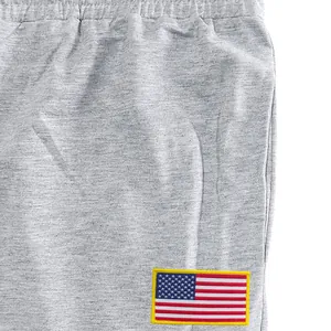 Detailopname van grijze joggingbroek voor heren met Amerikaanse vlag-patch en zak