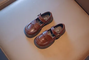 Detail of girls' brown Mary Jane shoes with scalloped edges and buckle straps.