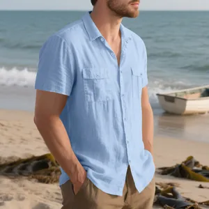 Dettaglio di una camicia in lino azzurro da uomo con doppie tasche sulla spiaggia.