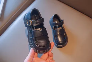 Close-up detail of black leather Mary Jane shoes for girls featuring a scalloped design