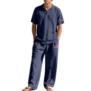 Heren set van marineblauwe linnen polo en losse broek met vlag patches op de mouw.
