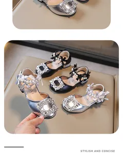Detalle de sandalias de princesa para niña en plateado y negro con hebillas de strass