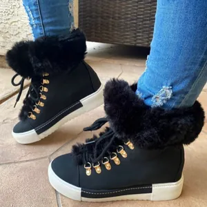 Detail of black leather-look winter boots with thick faux fur trim and gold hardware