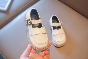 Close-up of elegant beige girls' Mary Jane leather shoes featuring a vintage metal buckle.