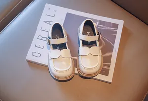 Elegant cream girls' British style leather Mary Jane shoes shown on a magazine