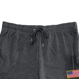 Detailopname van een houtskoolgrijze joggingbroek met elastische taille en Amerikaanse vlag.