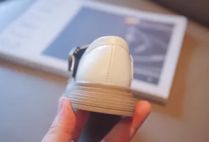 Detailed close-up showing the sturdy heel stitching and textured sole of girls leather shoes