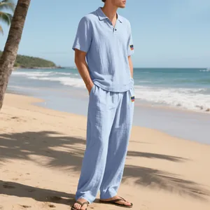 Lichtblauwe linnen set voor heren met poloshirt en lange broek op tropisch strand