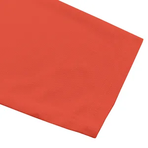 Primo piano del tessuto a nido d'ape traspirante e cuciture di una polo arancione