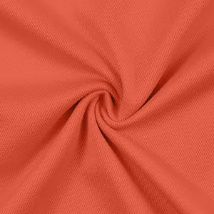 Macro dettaglio della trama del tessuto a rete arancione traspirante per polo di alta qualità.