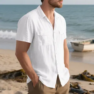 Detail view of men's white linen short sleeve cargo shirt with double pockets on beach.