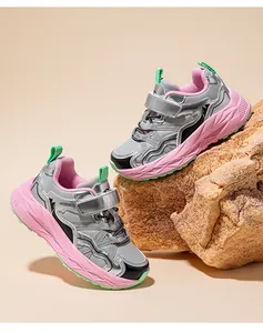 Detailansicht der silbernen Jungen-Sneaker mit rosa Plateausohle auf Felsen