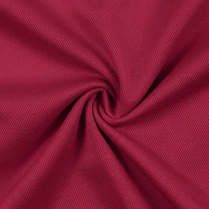 Macro-detail van ademende bordeauxrode mesh-stof met een zeer fijne gebreide textuur