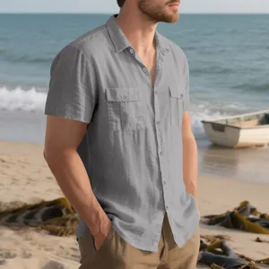 Detailed view of a grey linen cargo short sleeve shirt with pockets on a sunny beach