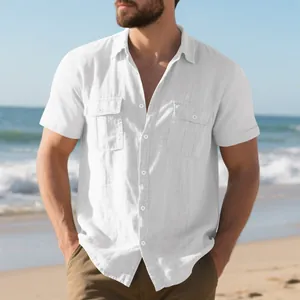Detail of a men's white linen short-sleeved shirt with double chest pockets on a beach.