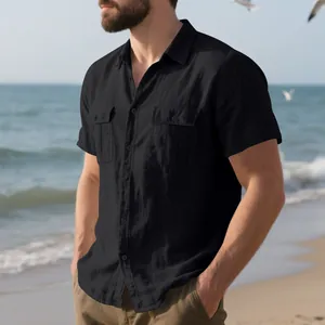 Detail of men's black short-sleeved linen shirt with two pockets on model at beach