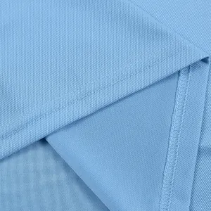 Vista macro della trama del tessuto piqué blu e delle cuciture dell'orlo della polo da uomo