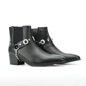 Detailansicht schwarzer Herrenmode-Stiefel mit Silberkette und verzierten Medaillons.