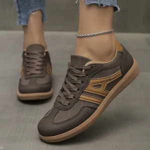 Detail view of brown German army style casual sneakers with lace-up design on foot