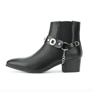 Detailansicht eines schwarzen Leder-Stiefeletten mit Silberkette und Medaillon-Riemen.