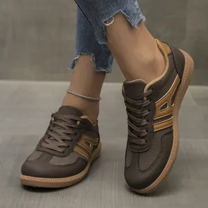 Close-up of brown casual German trainer sneakers with lace-up design and flat sole.