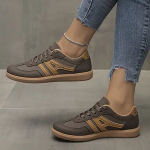 Detailed view of casual brown women's German Army Trainer sneakers styled with denim jeans