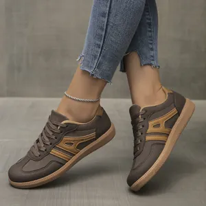 Close-up detail of women's brown German Army Trainer sneakers with tan stripe accents.