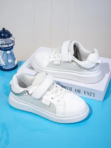 Λεπτομέρεια λευκών παιδικών sneakers με πλέγμα και ασημένια διακοσμητική αλυσίδα