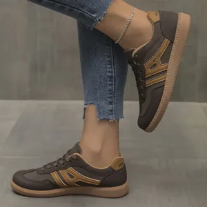 Detailed view of comfortable brown lace-up German Army Trainers sneakers worn with jeans
