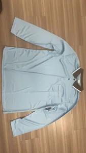 Vista piatta di una polo a maniche lunghe da uomo, azzurro chiaro, vestibilità ampia