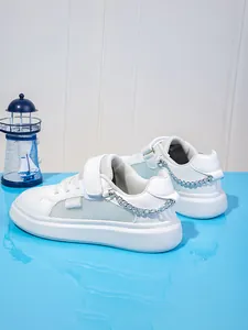 Λεπτομέρεια από λευκά κοριτσίστικα sneakers με πλατφόρμα, πλέγμα και ασημένια αλυσίδα.